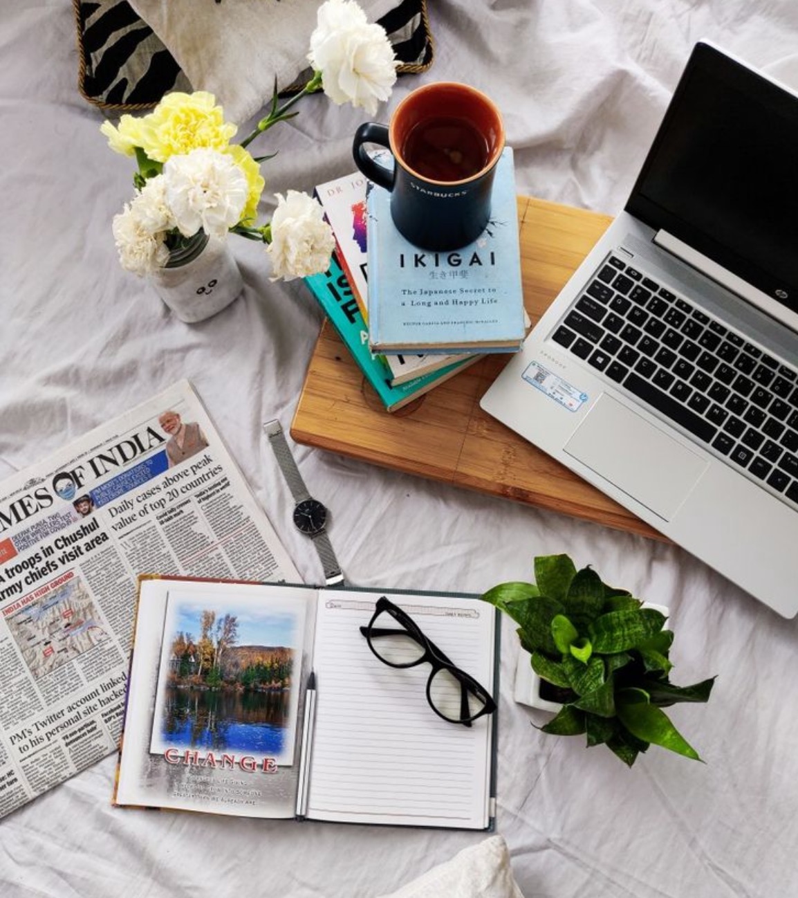 Laptop and notebook open on a desk, representing writing a blog post and newsletter